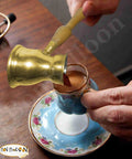 Old School Hand Hammered Solid Brass Copper Ibrik Pot Coffee Maker With Wooden Handle pouring coffee into cup