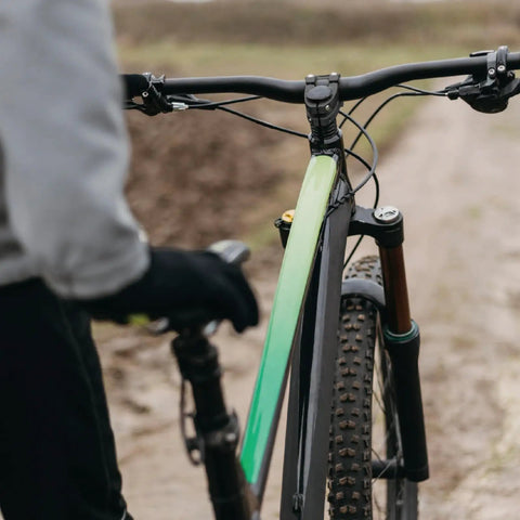 Cyclist with Beefy Aluminum Bike Stem 25.4mm Or 31.8mm Handlebar Fit, wooded trail, black handlebar visible.
