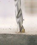 Carbide Tipped Percussion Masonry Hammer Drill Bit 5/16 x 6 in drilling into concrete, showing wide roll forged flutes.