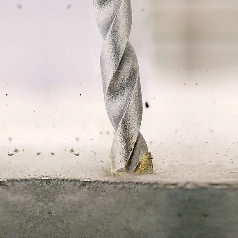 Carbide Tipped Percussion Masonry Hammer Drill Bit 5/16 x 6 in drilling into concrete, showing wide roll forged flutes.