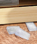 8 Pack Clear Furniture Leveler Shims Non Slip Rubber Table Wedges For Uneven Floors near a furniture leg on hardwood.