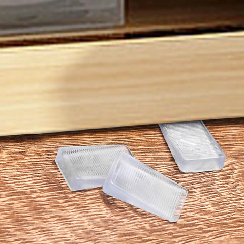 8 Pack Clear Furniture Leveler Shims Non Slip Rubber Table Wedges For Uneven Floors near a furniture leg on hardwood.