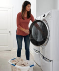 Woman using Hip Hugger Laundry Basket With Easy One Hand Carry Grip One And A Half Bushel White Hamper Lightweight Stackable Organizer