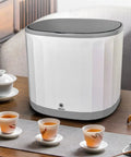 Compact Countertop Dishwasher With 4 Liter Built In Tank And 360 Rotating Spray Head Usb Rechargeable Portable Cleaner For Rv Camping Dorms Tiny Homes No Sweat Quick Rinse Easy Peasy Setup Weekend Warrior Approved on a wooden table with tea cups.