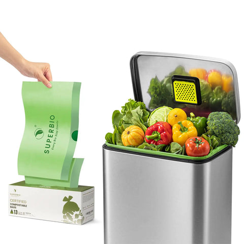 Person holding a 13 Gallon Compostable Drawstring Kitchen Waste Bag near compost bin filled with vegetables, 49.2 Liter, 1 Mil, BPI Certified.