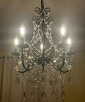 Black Crystal Chandelier With 5 Lights, K9 Crystal Raindrops, Iron Ceiling Light Fixture, shining in dark room.