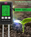 All In One 6 In 1 Soil Tester With pH Meter And LCD Display Measures Soil Moisture Temperature Humidity And Fertility For Gardening Lawn Farm And Outdoor Plants showing LCD screen and seedling.