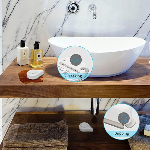 Zigbee Water Leak Sensor With Dripping Detection And 120 dB Alarm, 2 Pack No Fuss Setup, Real Time App Alerts, Works With Home Assistant And Compatible Zigbee Hubs, Batteries Included, Easy Floor Placement In Kitchen Basement Laundry. White plastic sensor on bathroom vanity detecting leak and drip.