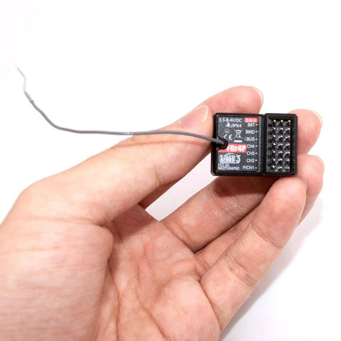 Hand holding FGr4P 2.4GHz AFHDS 3 Four Channel RC Receiver with PWM PPM I Bus S Bus outputs for RC cars and boats.