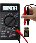 Hand using Digital Multimeter DT-830D With AC DC Measurement, Diode And Transistor Test, Continuity Buzzer, displaying 1.7
