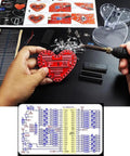 Person soldering Heart Shaped LED Flashing Light Kit With 51 Microcontroller For Electronics, 32 Colorful 5mm LEDs.