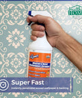Hand holding 22 oz bottle of Worlds Best Wallpaper Stripper And Sticky Paste Remover Citrus Scent Super Concentrate for easy use.