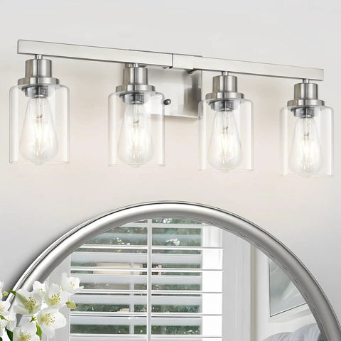 Four Light Brushed Nickel Bathroom Vanity Light With Clear Glass Shades above mirror in modern bathroom.