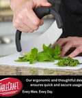 TableCraft H6610 mezzaluna with black handle and curved stainless steel blade for chopping herbs.