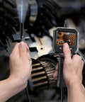 Handheld Endoscope Camera With 2.8 Inch IPS Display And Eight LEDs inspecting mechanical parts in close-up.