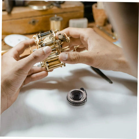 Hands repairing clock with Coil Spring For Mechanical Clock Repair And Vintage Alarm Clock Quill Spring Assembly part shown
