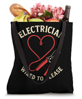 Black canvas shoulder bag filled with groceries, featuring 'Electrician Wired To Please' graphic design.
