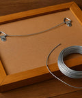 14 Gauge Galvanized Steel Wire 100 Ft Self-Tying Craft Wire For Picture Hanging shown with wooden picture frame