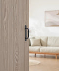 12 Pack 5.8 Inch Aluminum Alloy Black Cabinet Pulls With Screws installed on a light wood barn door in a modern living room setting.