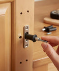 Spring Loaded Cabinet Hinge Repair Pins For Stripped Screw Holes Gold Plastic And Metal Anchor Kit 24 Pack Universal Fit For Standard Kitchen And Bathroom Hinges Quick Install, hand installing pin in wood cabinet hinge