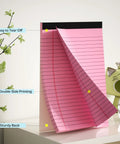 Pink 5x8 inch college-ruled legal pad with micro perforation, easy to tear off, showcased on desk with plant decor.