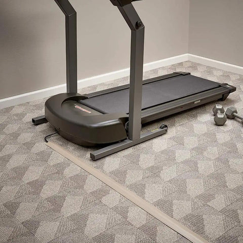 Ivory Cord Cover Kit For Wall Mounted TV 15 Ft Cable Concealer Channel on carpeted floor with treadmill