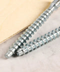 M7x70mm Hex Socket Countersunk Self Tapping Furniture Screws close-up on marble surface, flat head, carbon steel, zinc plated