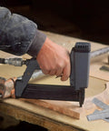 Close-up of hand using pneumatic staple gun with 18 gauge staples on wood for No Sweat 1609 Piece Pneumatic Staple And Nail Bundle.