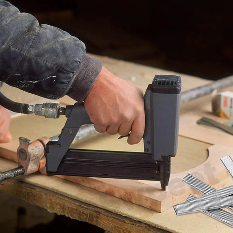Close-up of hand using pneumatic staple gun with 18 gauge staples on wood for No Sweat 1609 Piece Pneumatic Staple And Nail Bundle.