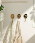 Super Clean Set Of Three Straight Up Vintage Wall Hooks With French Garden Floral Details And Classic Scalloped Metallic Hardware For Entryway Organizing And Cozy Bedroom Vibes, displaying coats and tote bags.