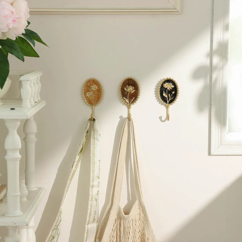 Super Clean Set Of Three Straight Up Vintage Wall Hooks With French Garden Floral Details And Classic Scalloped Metallic Hardware For Entryway Organizing And Cozy Bedroom Vibes, displaying coats and tote bags.