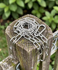 Heavy Duty Stainless Steel Chain Gate Latch With Double Carabiner Hooks For Pet Cages and Dog Fences on wooden post.