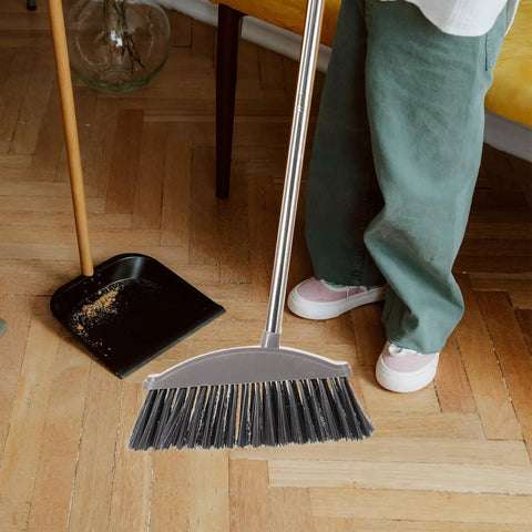 Dark Grey Angle Floor Broom With Long Stainless Steel Handle And Dense Stiff Bristles snags pet hair and kitchen messes.