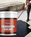 Rock-Solid Heavy-Duty Foundation Sealant Workhorse And Rubber Silicone Waterproof Sealant For Basement Leak Repair And Shower Liners Planter Boxes Coating Indoor Outdoor Black 5 Gallon Tub being applied to floor by worker.