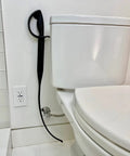 Better Than A Plunger Toilet Drain Snake Clog Remover hanging on wall next to toilet in bathroom