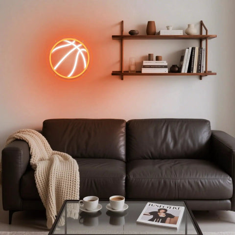 A basketball-shaped neon light on wall above a couch, not related to Dual Beer Shaped Neon Sign Light For Bar And Home Bar Setup LED.