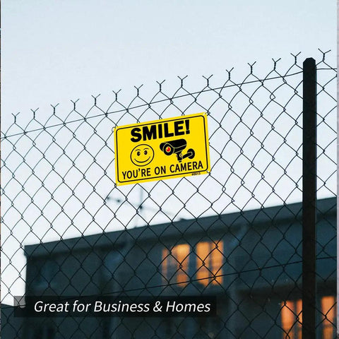 Two Pack Smile Youre On Camera Signs 10 By 7 Inch Funny Security Signs with smile face and camera icon on a fence