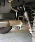 Close-up of car's underbody showing 304 Stainless Steel Exhaust Hanger 3 Inch 2 Pack Muffler Support on exhaust pipe