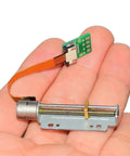 8mm Precision Stepper Motor With 2 Phase 4 Wire Linear Actuator And Metal Block Nut in hand, showcasing compact size and design.