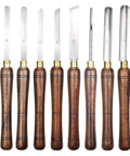 Dead Simple Wood Chisel Set Built Insanely Tough With High Carbon Steel Blades For Quick Wood Carving And Lathe Turning An Absolute Must Have Carpenter Gear Pack Kept Safe Inside A Classic Wooden Toolbox, featuring eight high carbon steel chisels with wooden handles.