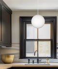10 Inch Mid Century Modern Globe Pendant Light With Frosted Glass Orb, White Finish, hanging in a stylish kitchen