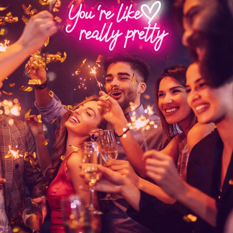 Lit Pink Neon Sign Youre Like Really Pretty Wall Decor LED Light Up Sign at a party with smiling people and confetti