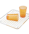 Stainless Steel Sink Grid Protector Kitchen And Bath Rugged Dish Rack with two orange cups on polished grid
