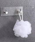 Heavy Duty Adhesive Wall Hooks That Are A Total Game Changer For Bathroom And Kitchen Organization Rust Proof Metal Hangers holding a white loofah.