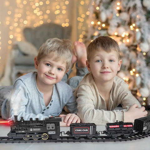 Two boys playing with Electric Train Set For Kids With Steam Locomotive And Cargo Cars Tracks And Railway Kit under Christmas tree