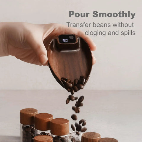 Hand holding walnut scoop with digital display, part of Espresso And Pour Over Coffee Scale With 0.1g Precision, showing coffee beans pouring