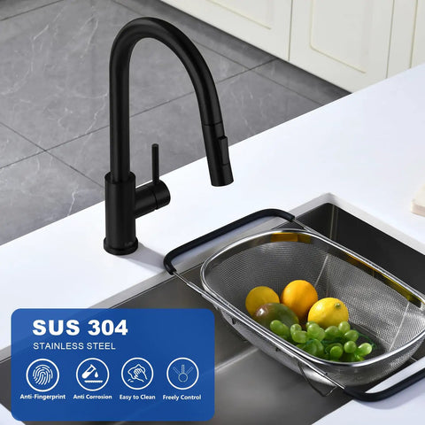 Slick Black Kitchen Faucet With Pull Down Sprayer Single Handle Modern Stainless Steel Kitchen Sink Faucet With Deck Plate Anti Fingerprint Finish SUS 304 Stainless Steel Construction next to a sink with fruit basket.