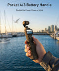 Person holding Extended 5000mAh Battery Grip For DJI Osmo Pocket 4 And 3 Xtra, cityscape and marina in background