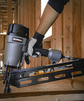 Hand holding Pneumatic 21 Degree Full Round Head Framing Nailer With Nails 2 To 3-1/2 Inch Length 500 Count Set, building a structure