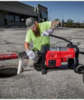 Thinking Process: worker using cordless drain cleaner with auto cable feed at outdoor sewer opening